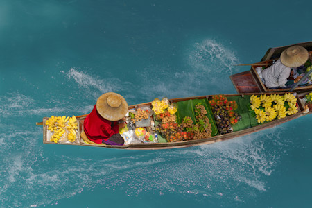 Vendors on boats selling local fruit  at the floating market in Bangkok